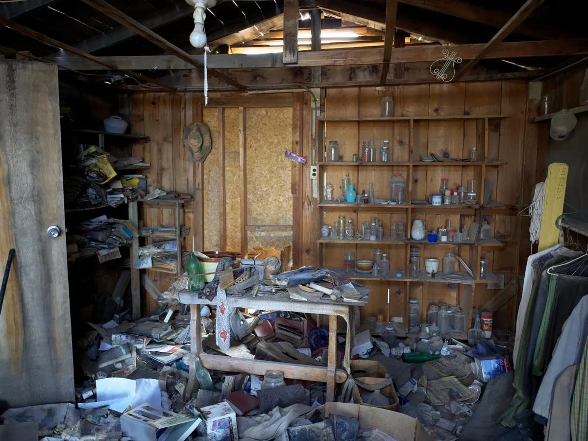 Heavily cluttered room with debris piled across the floor