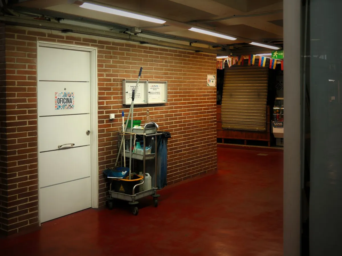Cleaning cart with mop and supplies parked by an office door